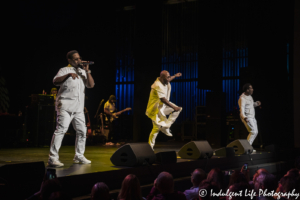 Boyz II Men baritone singer Nathan Morris singing while Wanya Morris and Shawn Stockman dance at the Kauffman Center in Kansas City, MO on October 2, 2019.