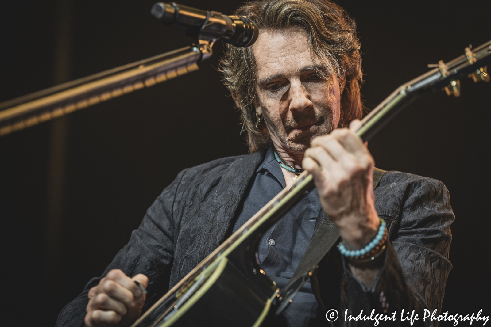 Rick Springfield playing the acoustic guitar during his concert with Richard Marx at Star Pavilion inside of Ameristar Casino in Kansas City, MO on August 24, 2024.